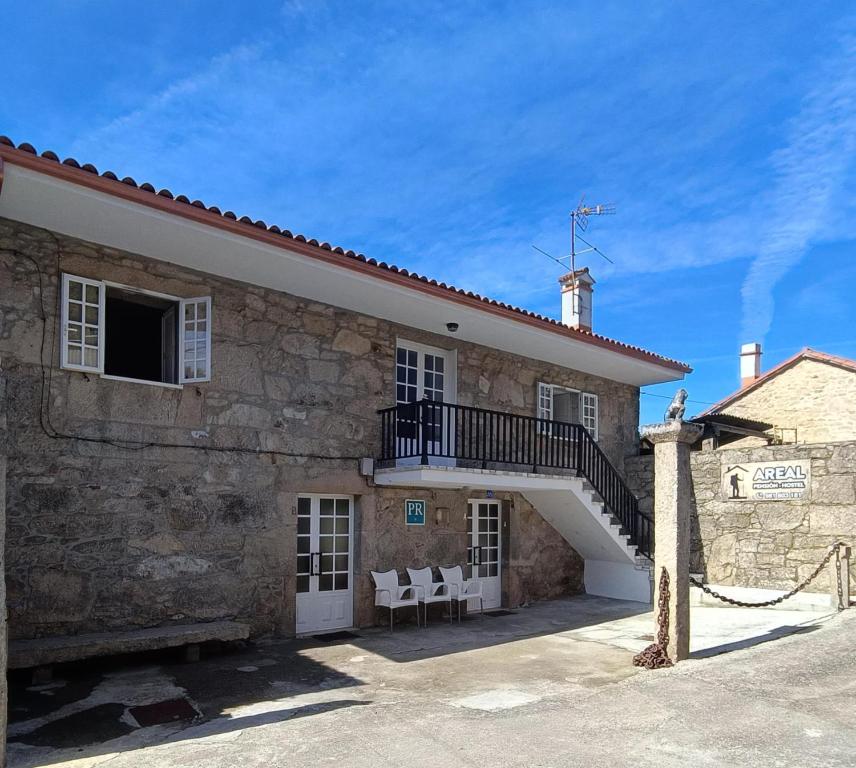 a building with a staircase on the side of it at Pensión Rural para Peregrinos "AREAL" in Padrón