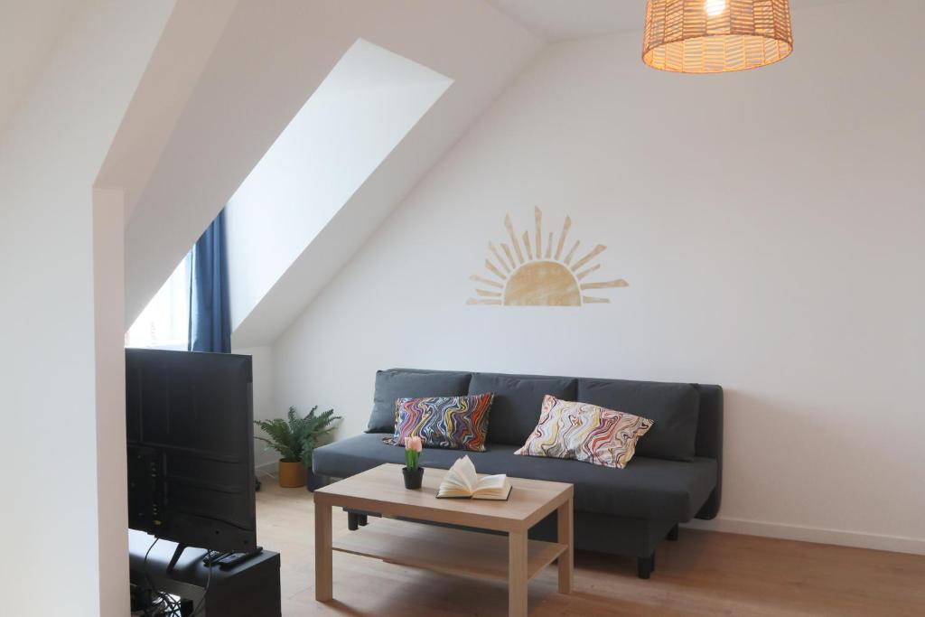 una sala de estar con un sofá y una mesa en LE SUNNY, Mulhouse centre, en Mulhouse