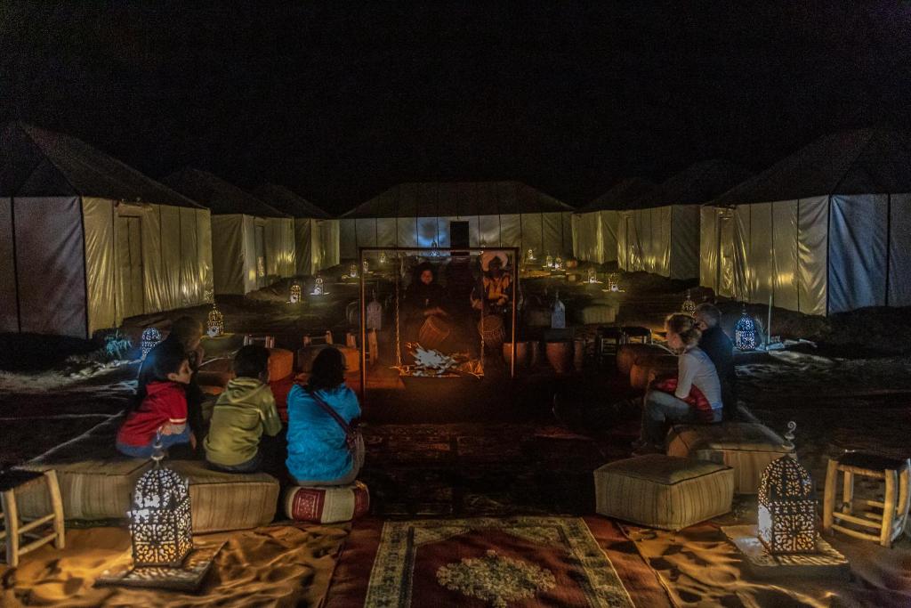 a group of children sitting on a couch at night at Erg Chebbi Desert Luxury Camp in Merzouga