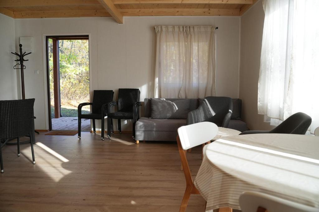 uma sala de estar com um sofá cinzento e cadeiras em Drewniany domek wakacyjny em Człuchów