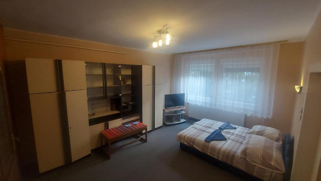 una camera da letto con un letto, una scrivania e una televisione di Sétány Apartmanház Fonyód a Fonyód