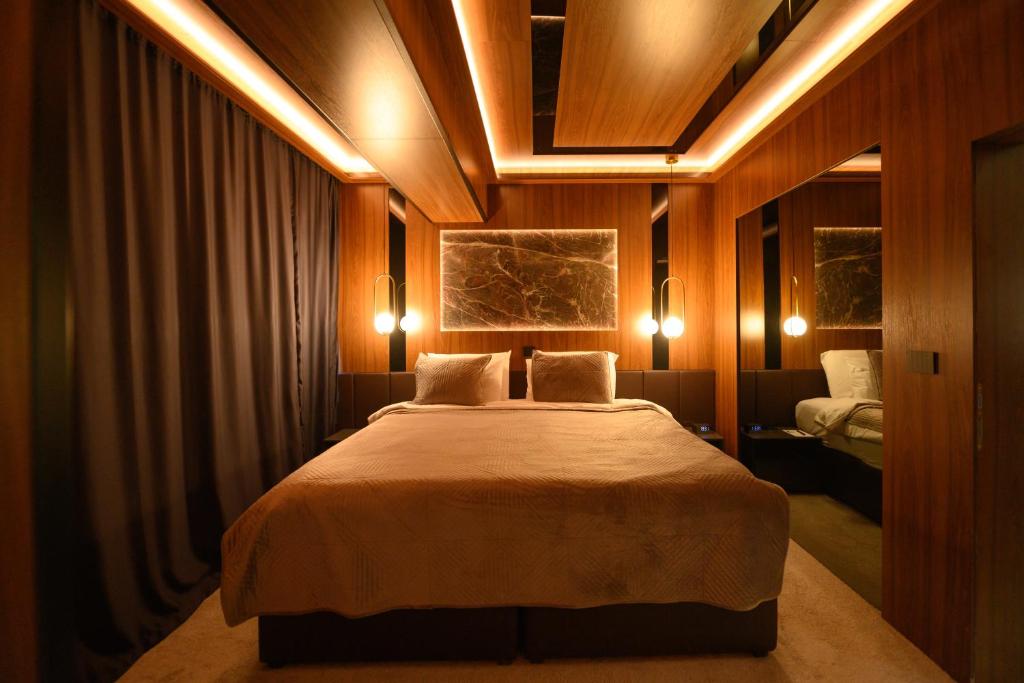 Hotel Macedonia Square في إسكوبية: غرفة نوم مع سرير كبير مع إضاءة عليه