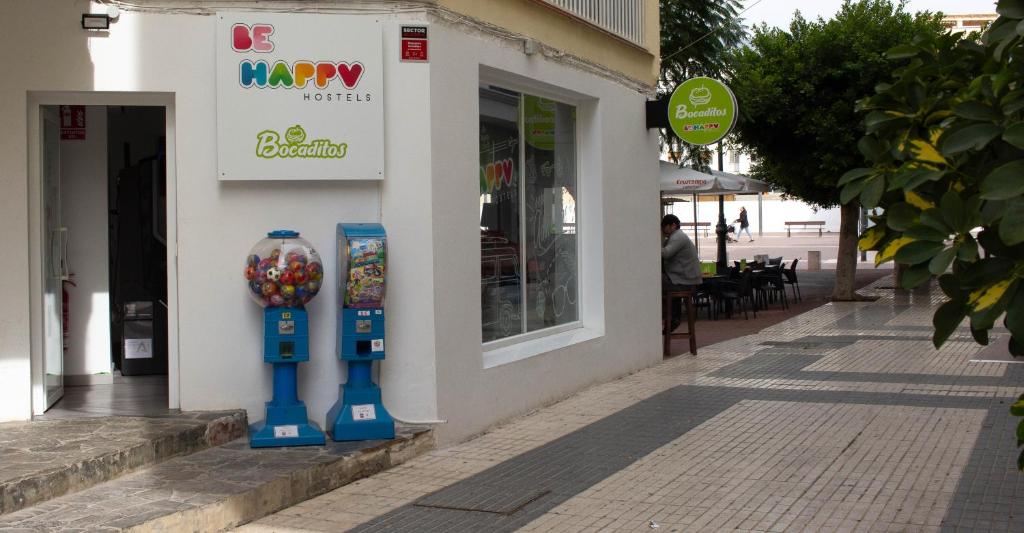 ein Geschäft mit zwei Parkuhren vor einem Gebäude in der Unterkunft Be Happy Hostel in Nerja