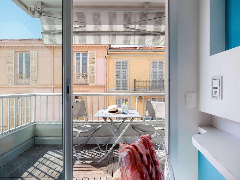 a balcony with a table and a view of a building at Ibis Styles Menton Centre in Menton