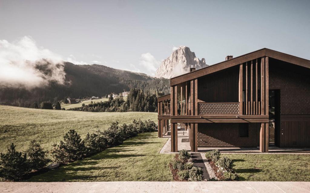 een houten gebouw met uitzicht op een berg bij Luxury Chalet Alpurio in Selva di Val Gardena