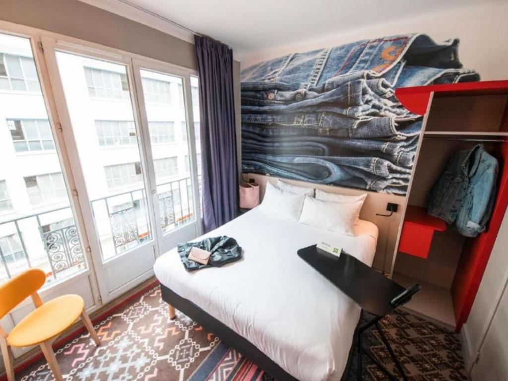 a hotel room with a bed and a large window at ibis Styles Lille Centre Grand Place in Lille