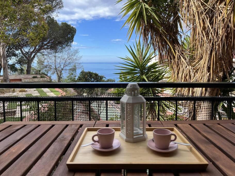 Una mesa de madera con dos tazas de café y una linterna. en Loft con vistas al Mar en Costa Brava, en Santa Cristina d'Aro