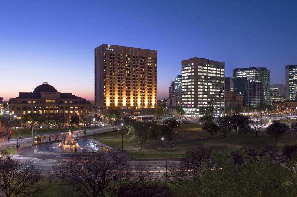 een skyline van de stad 's nachts met hoge gebouwen bij Hilton Adelaide in Adelaide