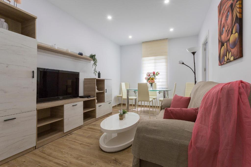 a living room with a couch and a tv at Playa Santa Maria Moderno 3 Rooms in Cádiz