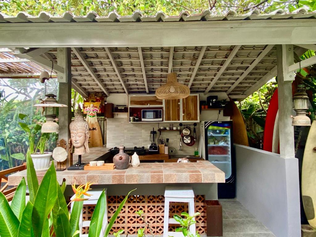 a kitchen with a counter and a refrigerator at Blue Waves Balangan Homestay in Uluwatu