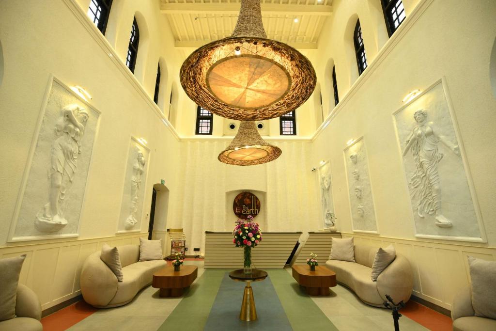 een grote lobby met banken en een grote kroonluchter bij The Earth Amritsar, Trademark Collection by Wyndham in Amritsar