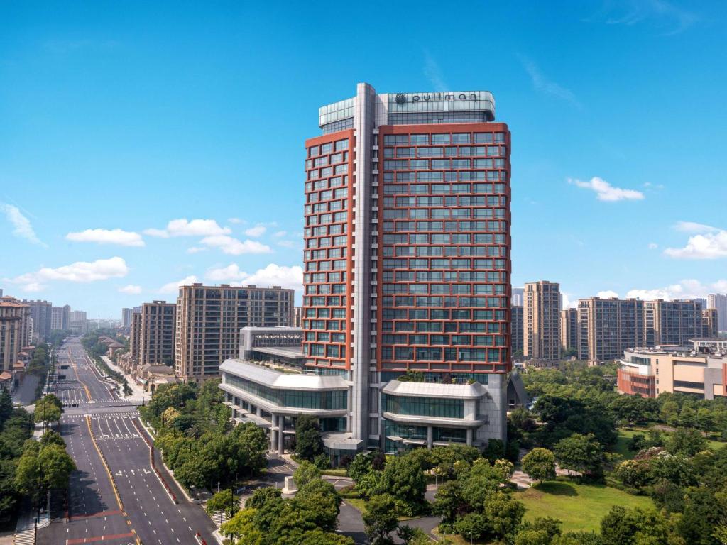 a tall building in the middle of a city at Pullman Haining in Haining