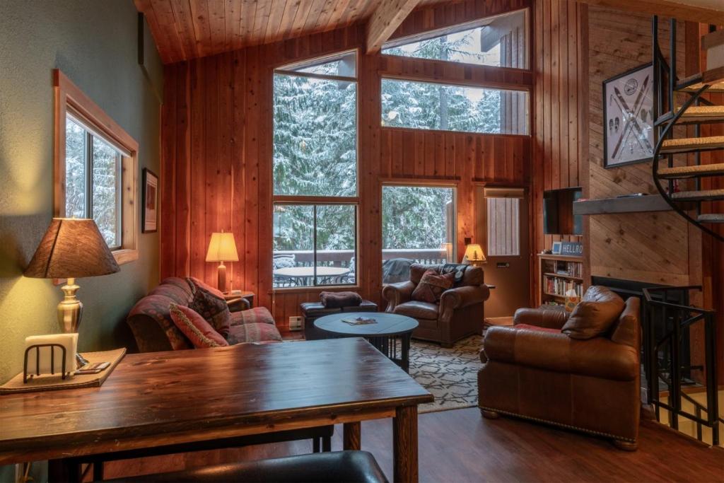 una sala de estar con paredes de madera y una gran ventana. en 98 Elk Horn, en Whitefish