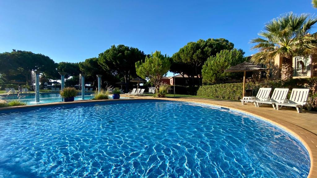 una gran piscina con sillas y árboles en Bicos R by Check-in Portugal, en Albufeira