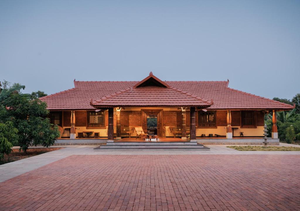 a house with a brick driveway in front of it at Panchavati Villa in Manipala