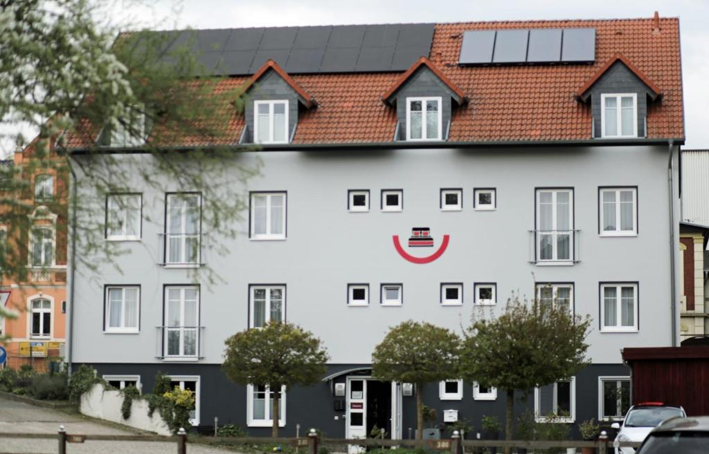 ein großes weißes Gebäude mit einem roten in der Unterkunft Hotel Zur Sonne in Waren (Müritz)