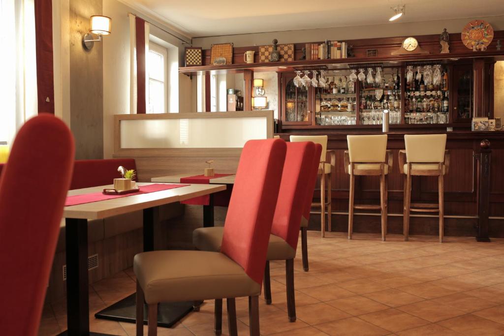 a restaurant with a table and chairs and a bar at Hotel Zur Sonne in Waren