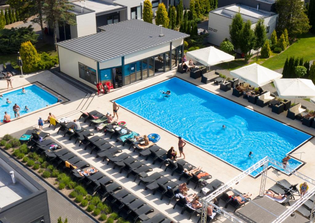 an overhead view of a swimming pool with chairs and people at Holiday Golden Resort & Spa in Łazy