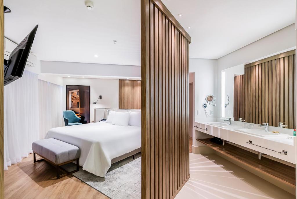 a hotel room with a bed and a bathroom at Radisson São Paulo Paulista in São Paulo