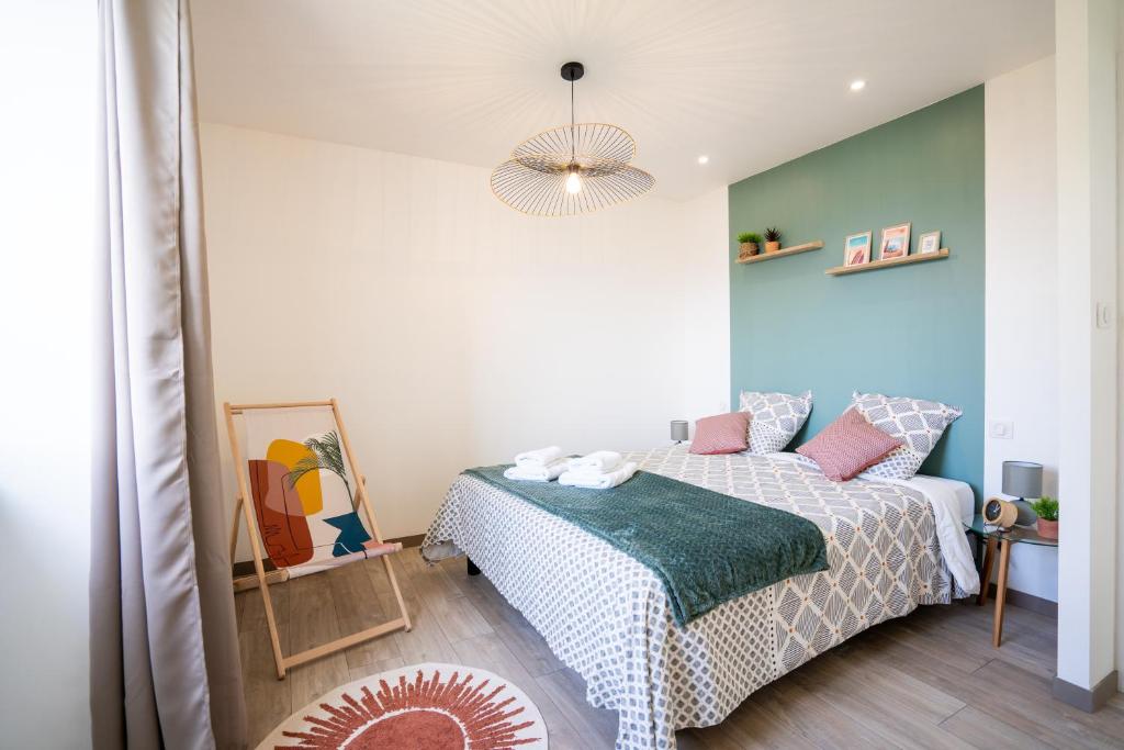 1 dormitorio con cama y lámpara de araña en Escapade Ocean, en Labenne