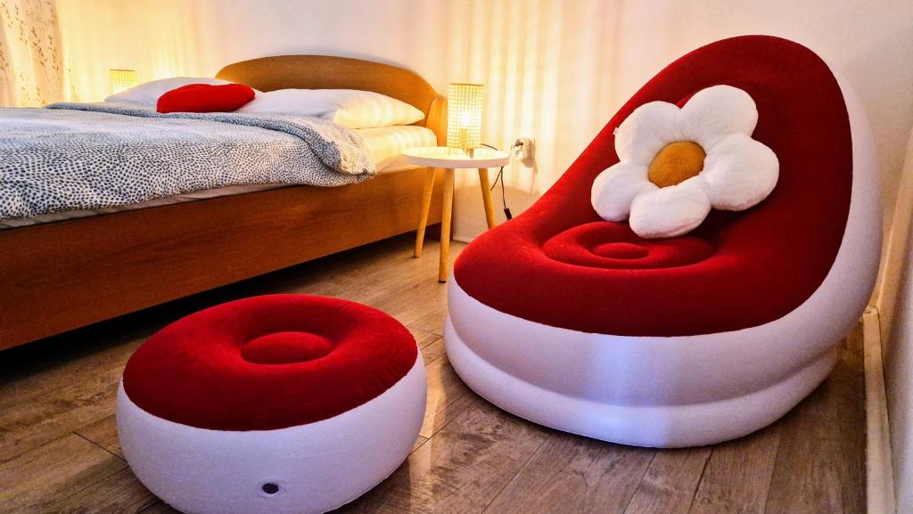 two red and white chairs in a bedroom with a bed at Urban Lights Hideaway in Šibenik