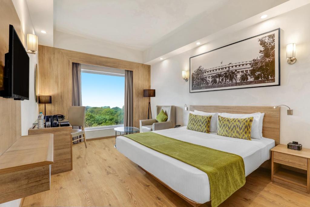 a hotel room with a large bed and a window at Lemon Tree Premier City Center in Gurgaon