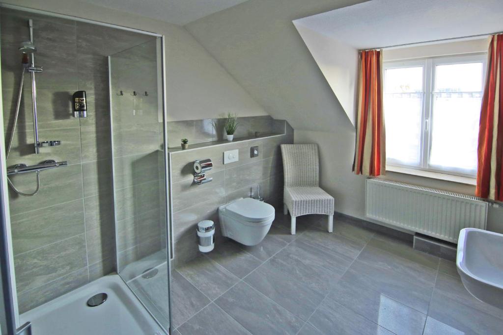 a bathroom with a shower and a toilet and a sink at Hotel Zur Sonne in Waren