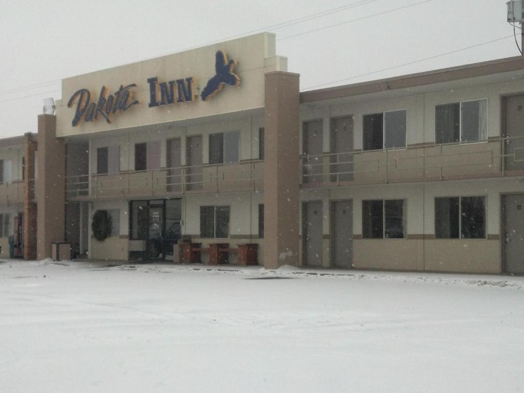 un edificio con un cartel en la nieve en Dakota Inn, en Huron