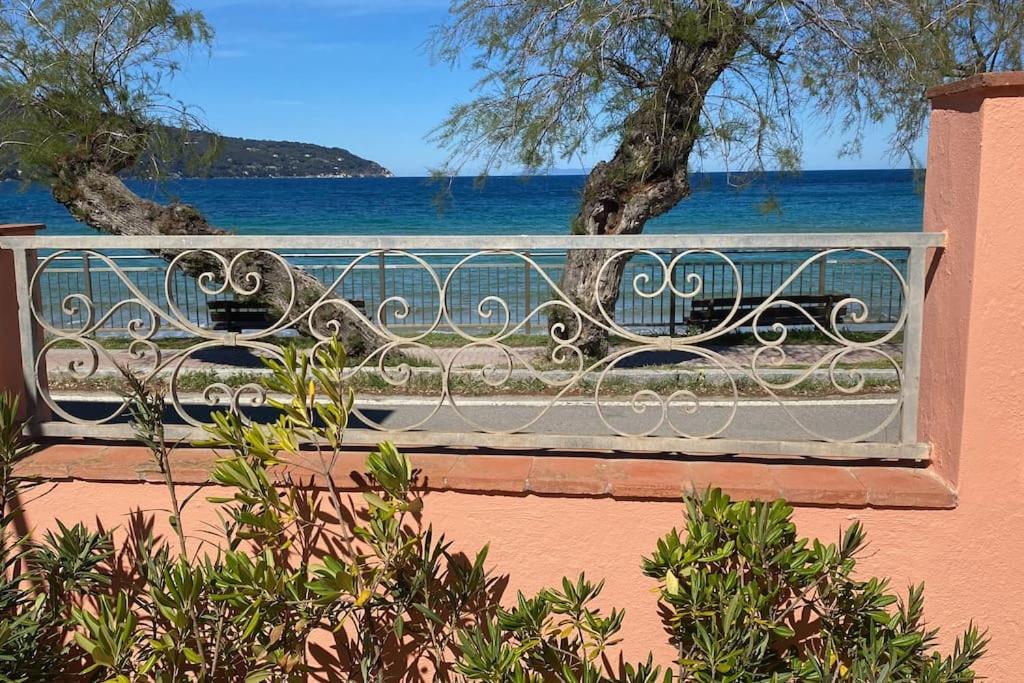 a bench sitting on a balcony overlooking the water at Casa sul mare in Procchio