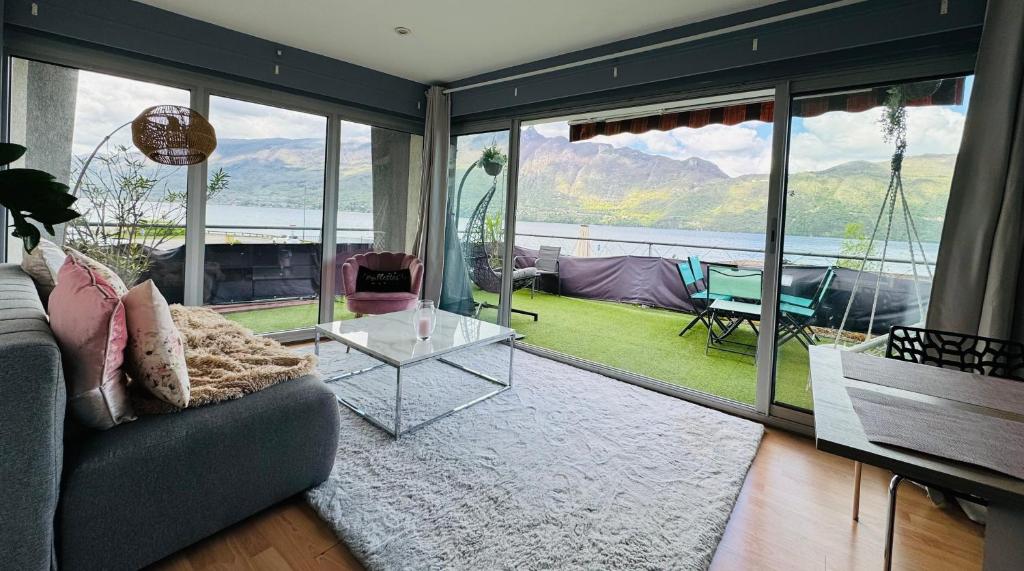 a living room with a couch and a glass table at Superbe Appartement avec vue sur le Lac du Bourget in Tresserves