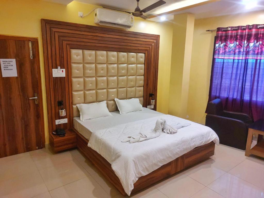 a bedroom with a large bed and a chair at Hotel Shobha Forbesganj in Forbesganj