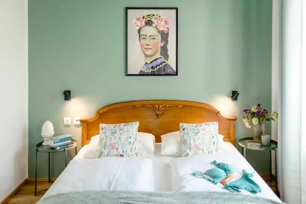 Un dormitorio con una cama con un retrato de un hombre en Boutiquehotel Hubertushof, en Bad Ischl