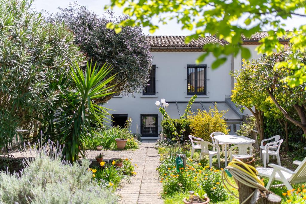 un jardin en face d'une maison blanche dans l'établissement la Voûte, à Carcassonne