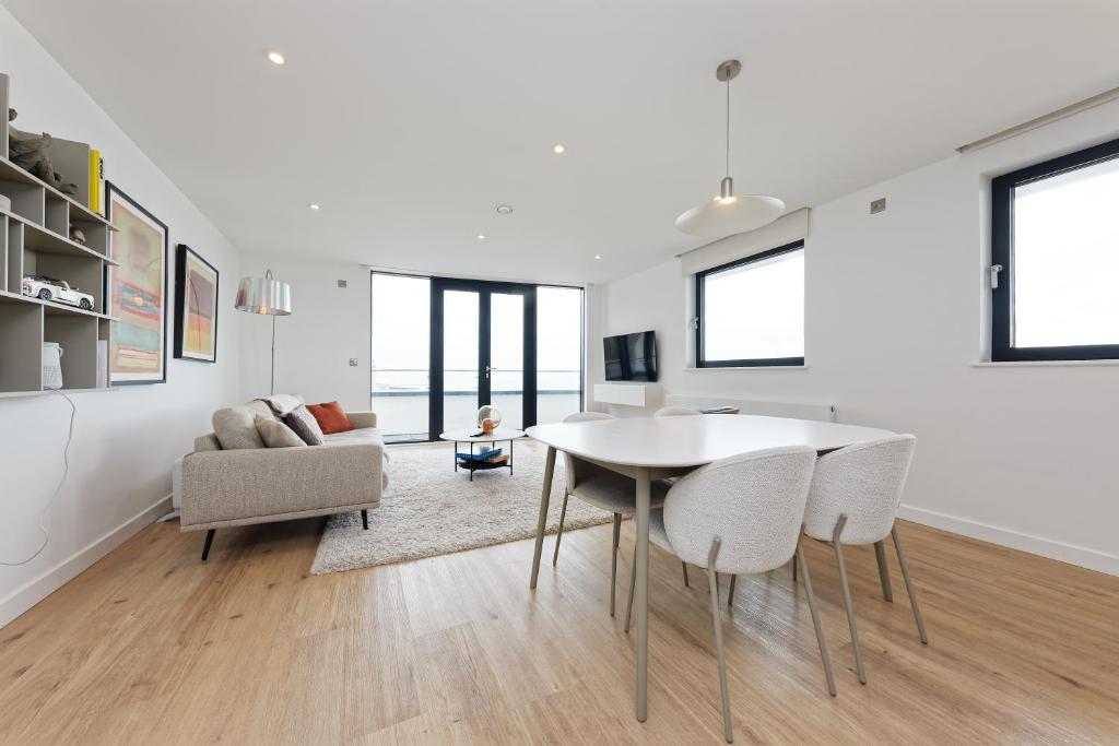 a white living room with a table and chairs at Gorgeous 2 Bed Apartment with Stunning Sea Views with Free Parking and Fast Internet in Ramsgate