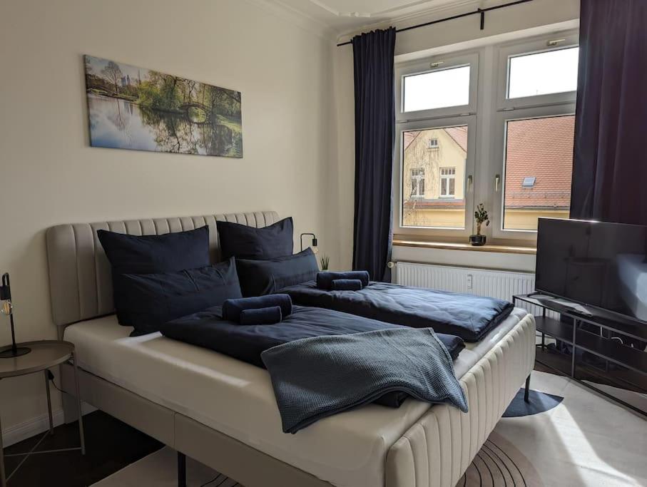 - une chambre avec un lit doté d'oreillers bleus dans l'établissement ViLiPa-Apartments No.5 I Baumwollspinnerei I Kunstkraftwerk - 75m² I Balkon I Smart-TV I Bad mit Fußbodenheizung, à Leipzig