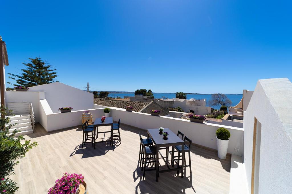 d'une terrasse sur le toit avec des chaises et des tables. dans l'établissement Baglio Tuzza, à Marsala