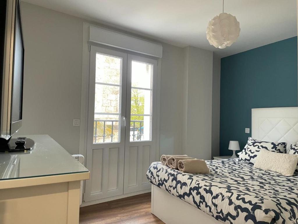 a bedroom with a bed with a blue wall at EL FAROLILLO DE LA CATEDRAL VIVIENDA DE USO TURISTICO VUT 9/251 in Burgos