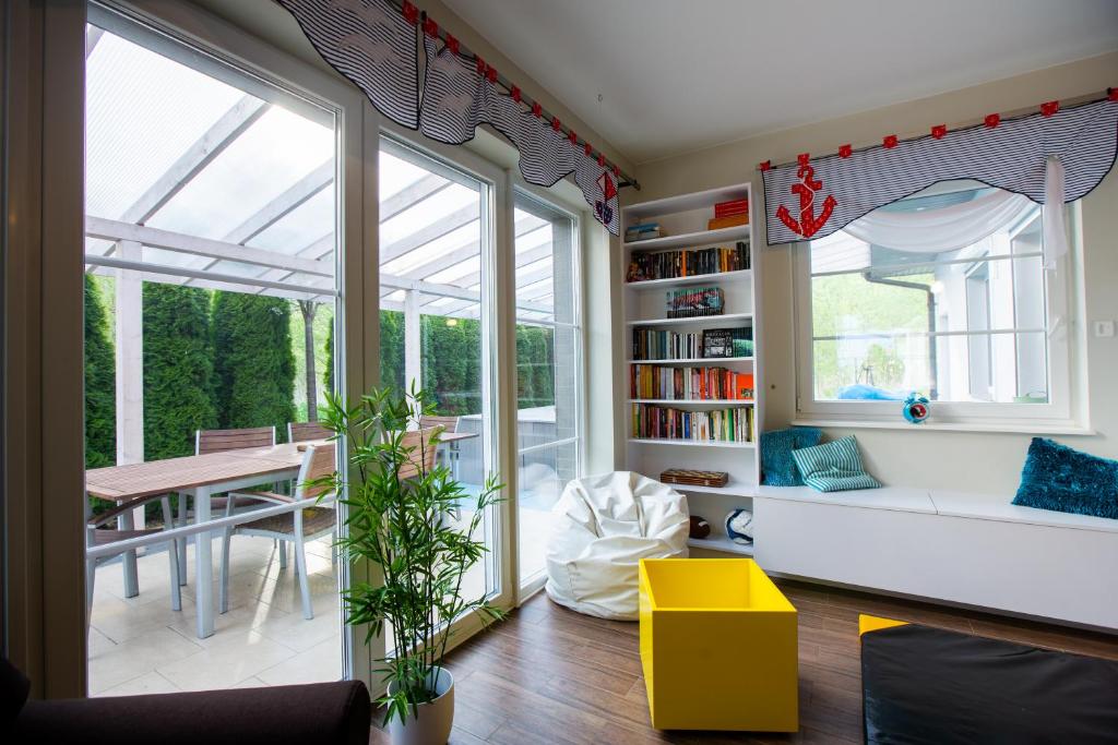 a living room with a conservatory with a couch and a table at Dom nad Morzem Pleśna78 in Pleśna