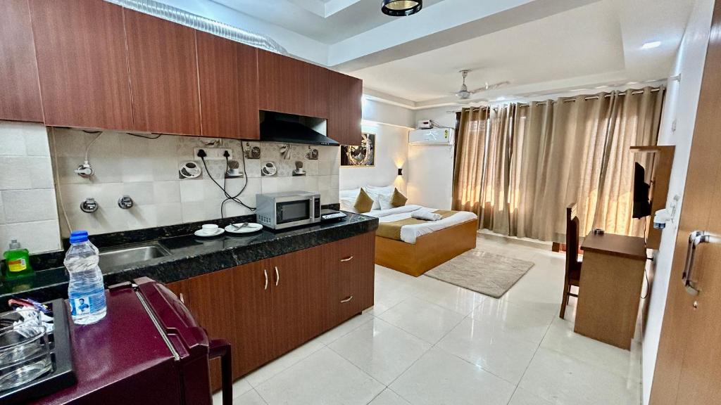グルガオンにあるAura Luxury Studio Near Golf Course Road, Sector 57, Gurgaonのキッチン、リビングルームが備わります。