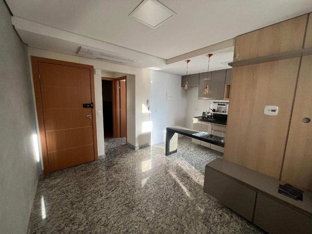 een kamer met een keuken en een hal met een deur bij Locking's Savassi 09 in Belo Horizonte