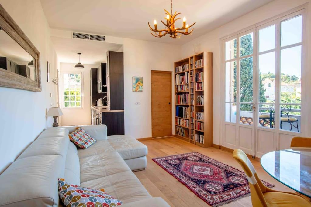 uma sala de estar com um sofá e uma mesa em The Cap - Charming apartment em Saint-Jean-Cap-Ferrat