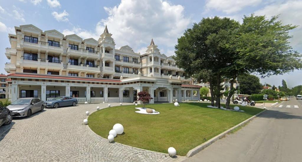 a large white building with a park in front of it at Smokini Beach Apartment in Sozopol
