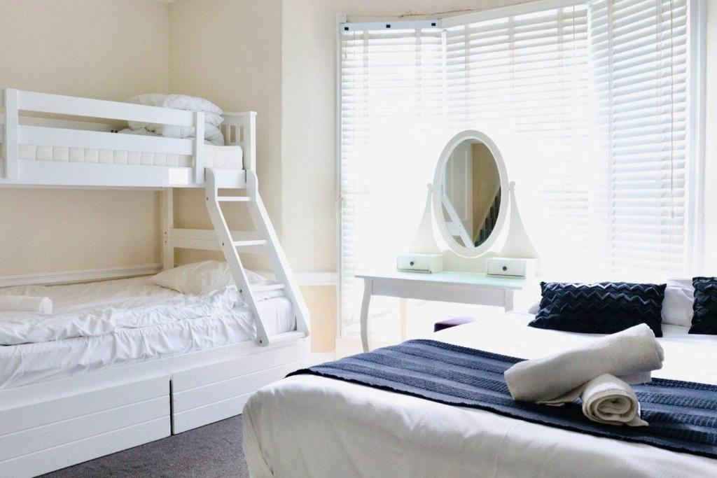 een slaapkamer met 2 stapelbedden en een spiegel bij Modern & Glamorous Home Brighton Pier Beach SLP16 in Brighton & Hove