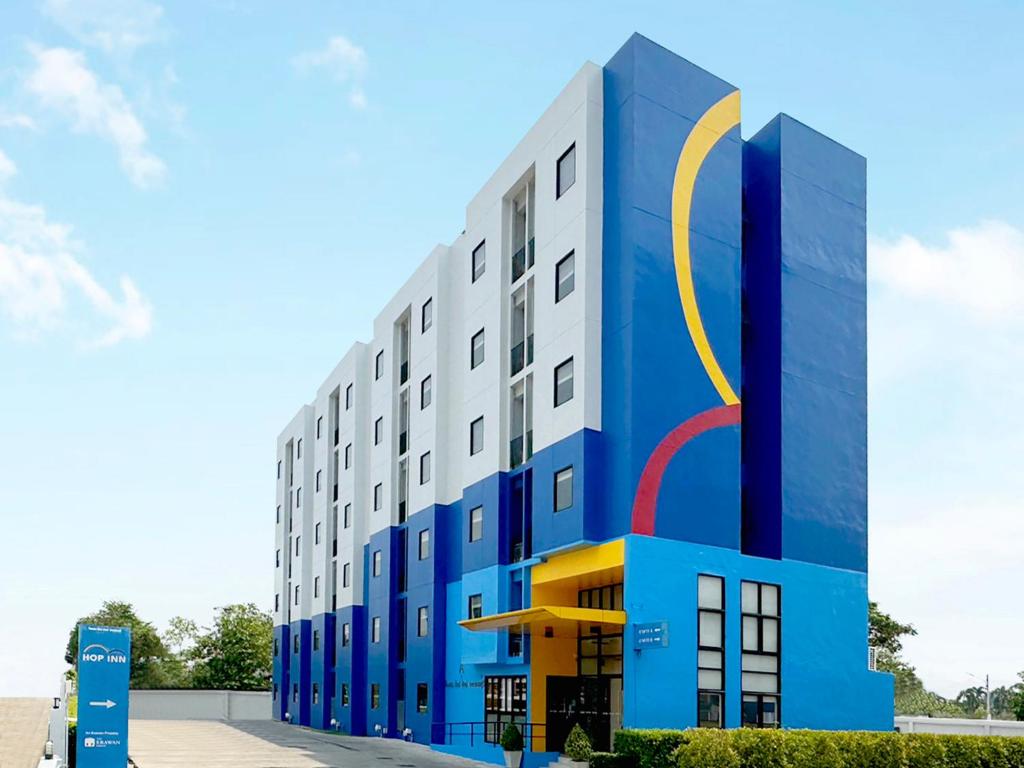 a blue and white building with a circle on it at Hop Inn Kanchanaburi Building A in Kanchanaburi