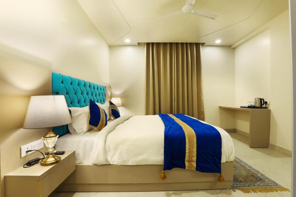 a bedroom with a bed and a blue headboard at OPO Hotels D'or in New Delhi