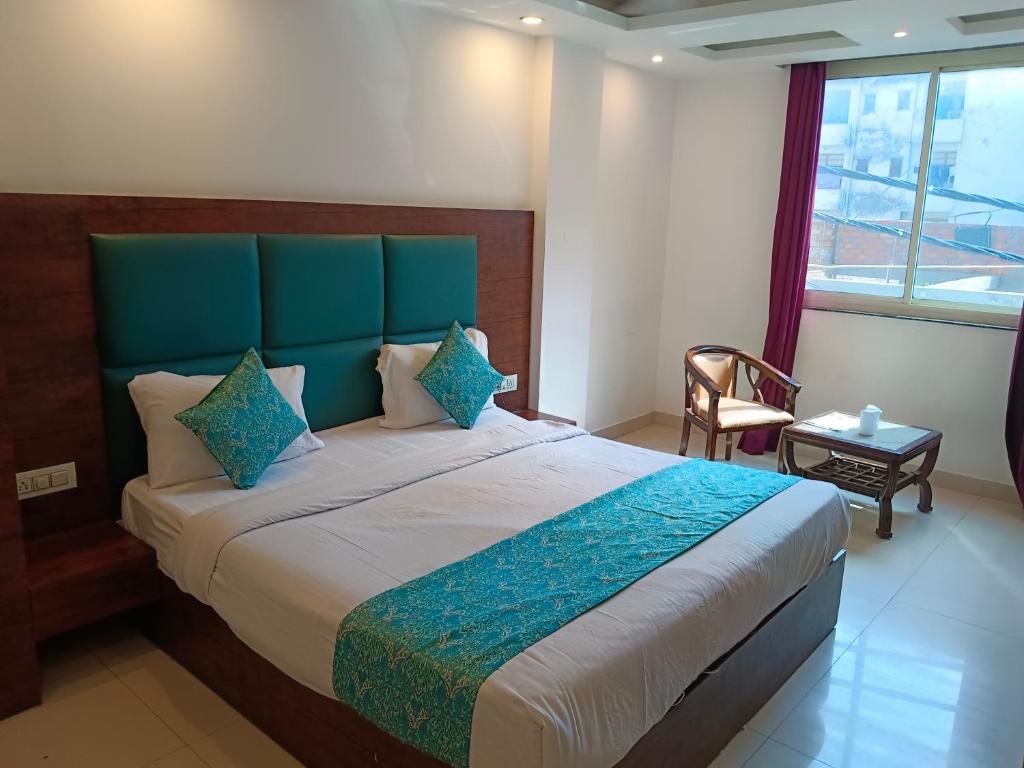een slaapkamer met een groot bed met een blauw hoofdeinde bij Hotel Tela Suite A Family Hotel Near Delhi Airport in New Delhi