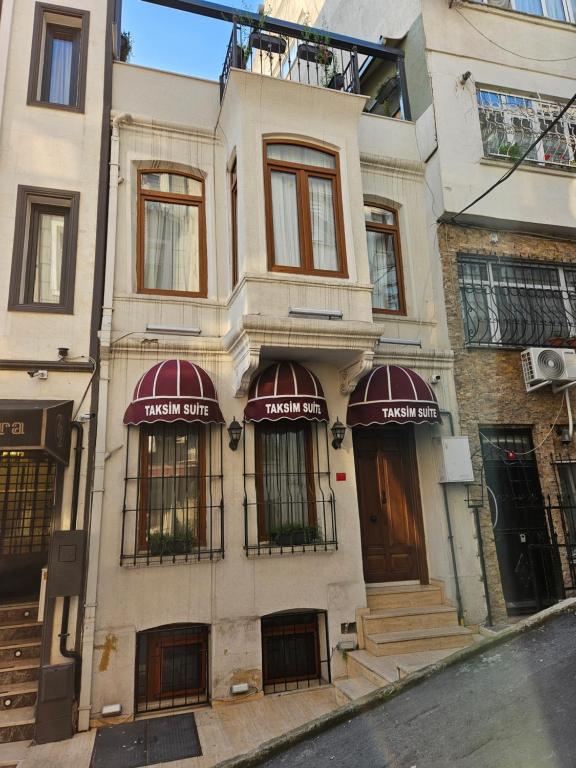 an apartment building with red awnings on a street at TAKSİM SUİTE in Istanbul