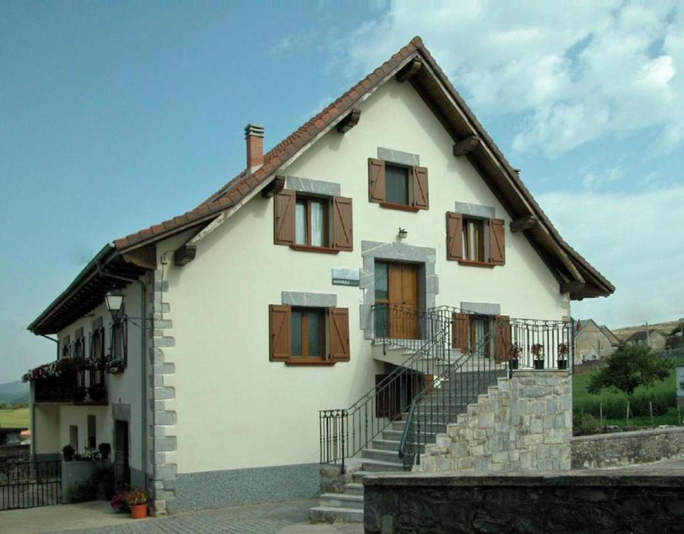 Casa blanca con ventanas de madera y escaleras en Casa Aguerre, en Villanueva de Aézcoa