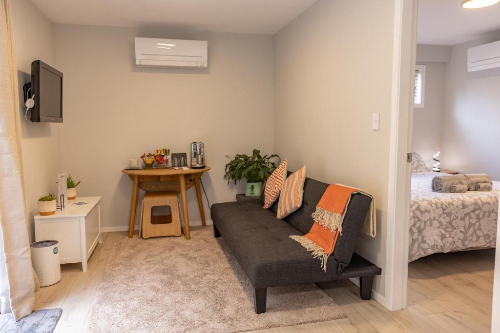 uma sala de estar com um sofá e uma cama em Back Garden Flat with Free On Street Parking and Fiber WIFI - 15 mins to Ferry, Stadium, CBD em Wellington