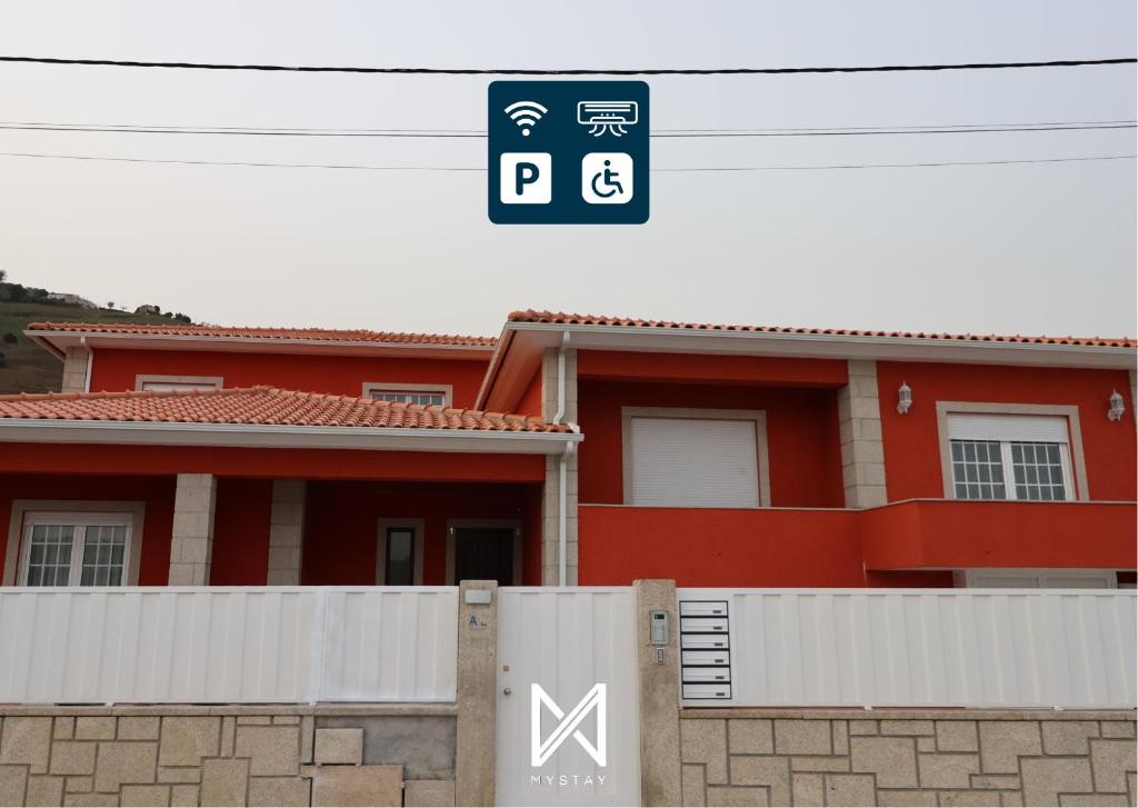 una casa roja con un cartel delante en MyStay - Oliveira Douro House, en Peso da Régua
